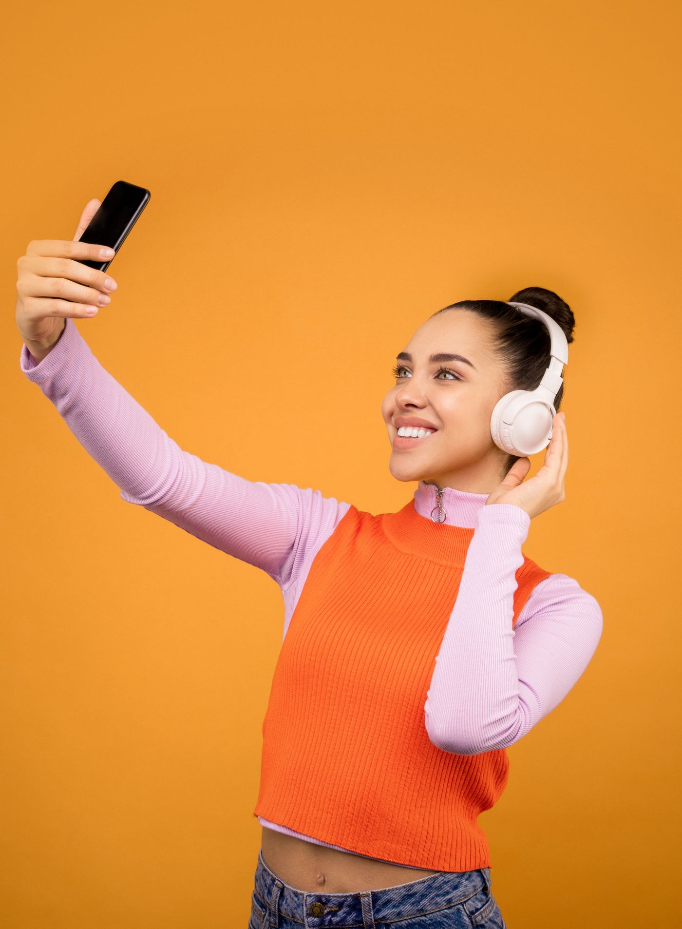 Mulher com fones de ouvido usando o celular